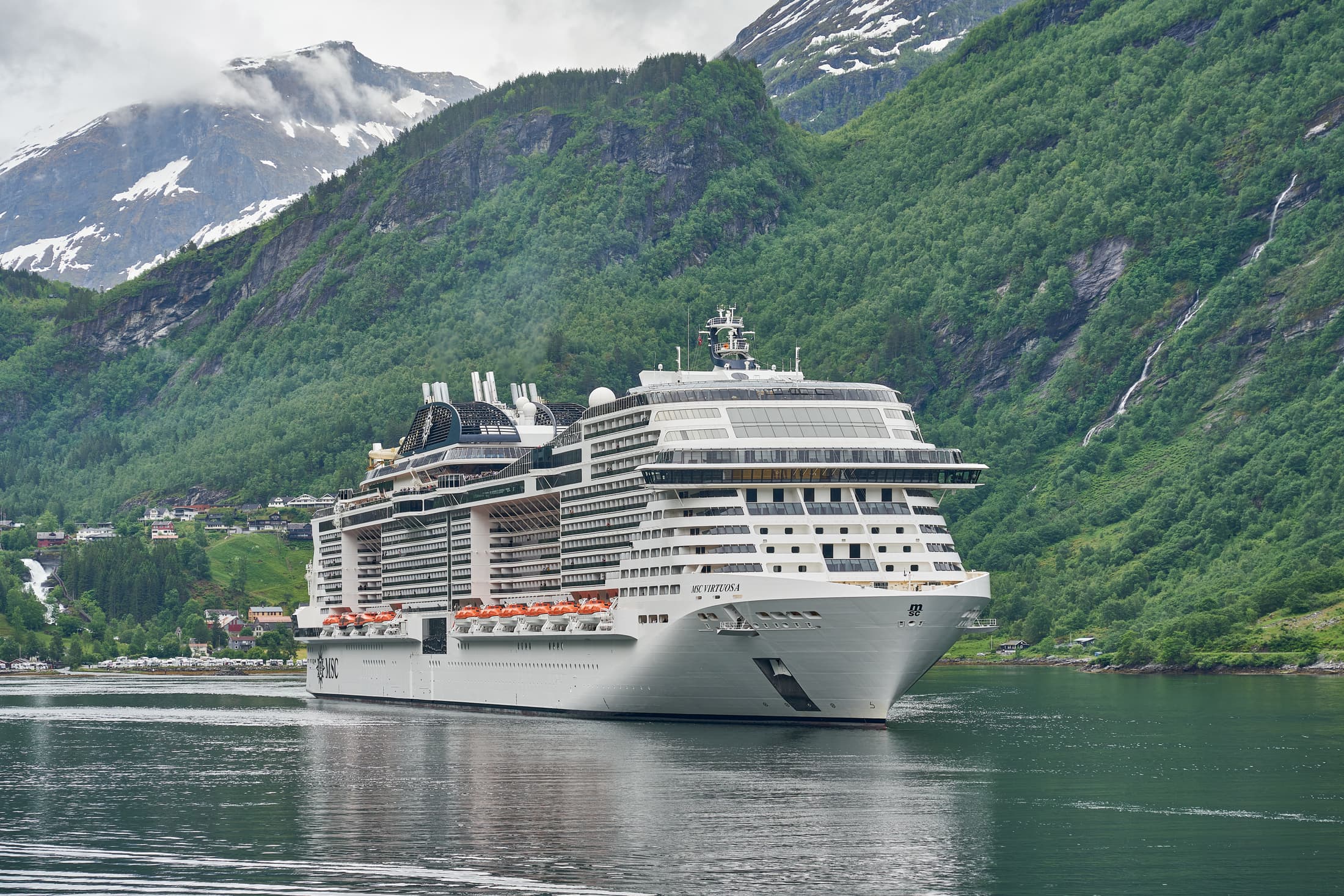Luxury cruise ship sailing through Geirangerfjord, Norway — viaUNO Cars cruise & airport transfer specialist Southampton